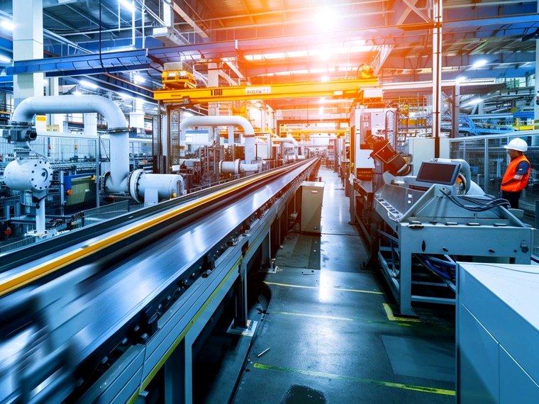 Interior of an automated production facility with overhead gantry and control panels